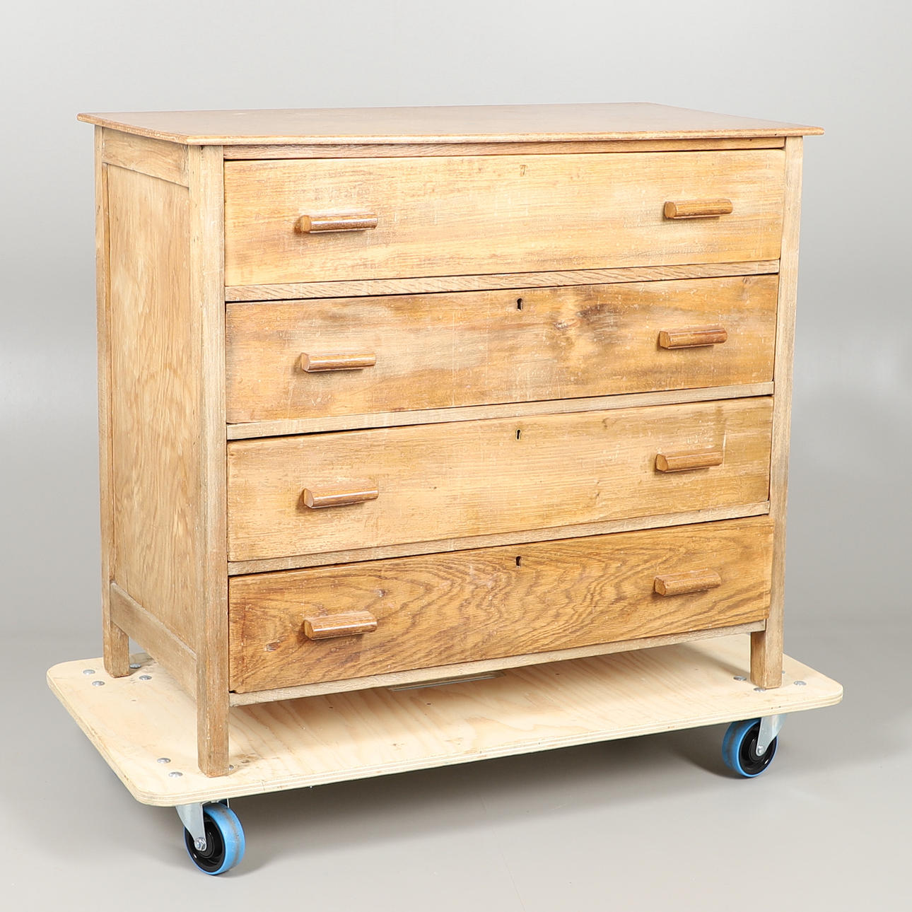 UNA CÓMODA DE ROBLE CLARO DE CAJONES DEL SIGLO XX.