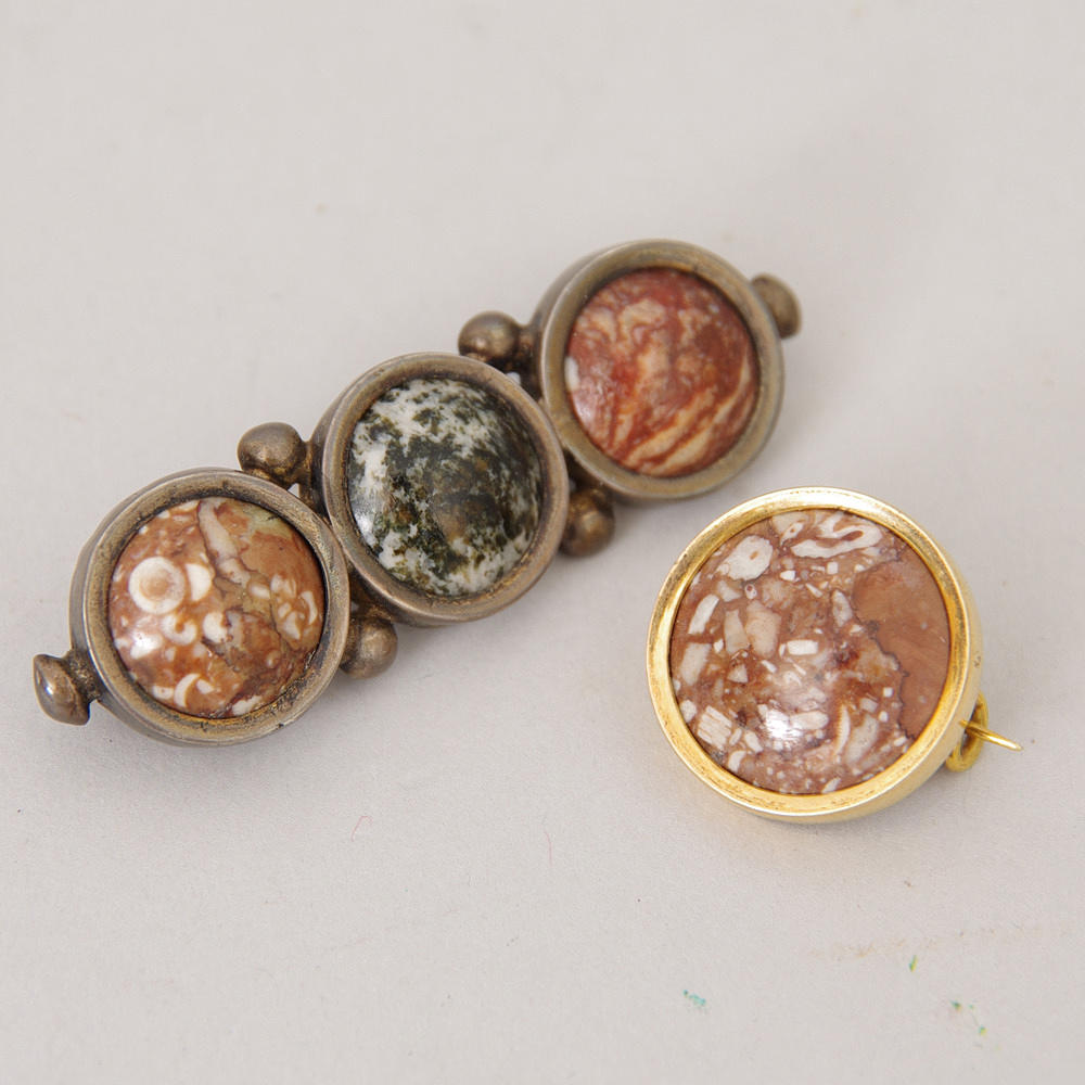 BROSCHER, 2 stycken, porfyr, en med silver Landskrona 1897, en med guld.