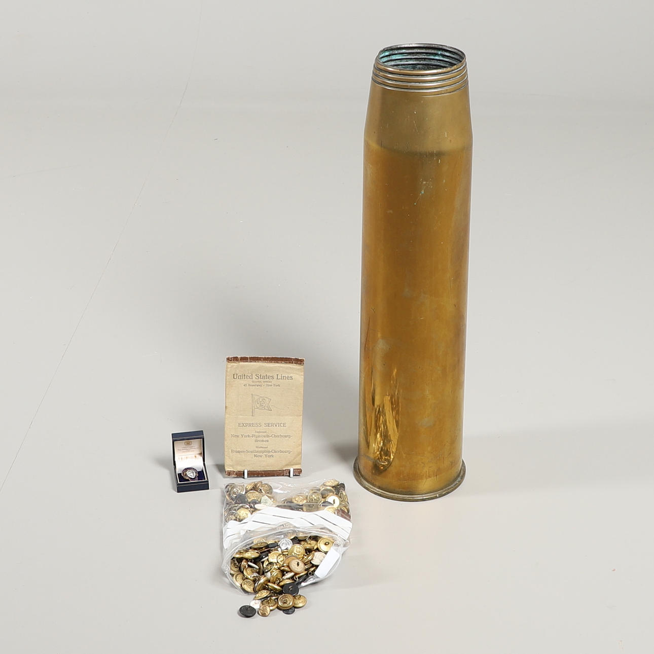 A COLLECTION OF ROYAL NAVY BUTTONS AND INSIGNIA AND A LARGE SHELL ...