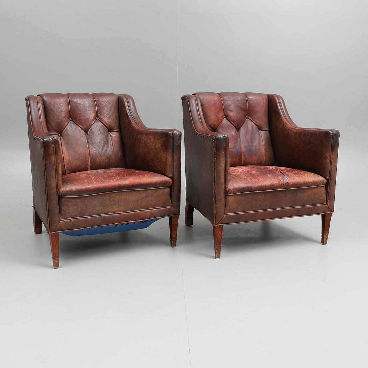 CLUBFÅTÖLJER, ett par, skinn, 1900-talets första kvartal.