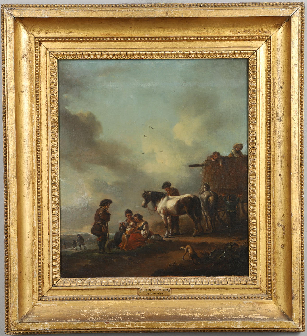 FOLLOWER OF PHILIPS WOUWERMAN (1619-1668). A RUSTIC FAMILY WITH HORSES BY A HAYCART.