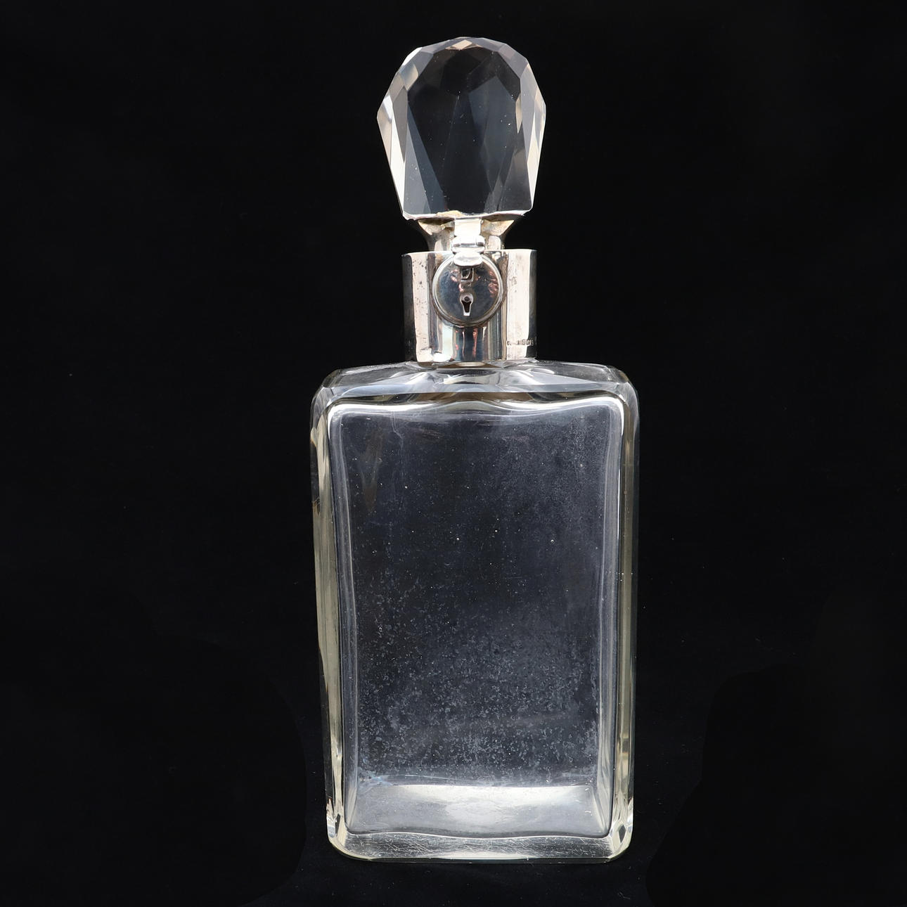 A GEORGE V SILVER MOUNTED RECTANGULAR GLASS LOCKABLE DECANTER, BY ASPREY LONDON.