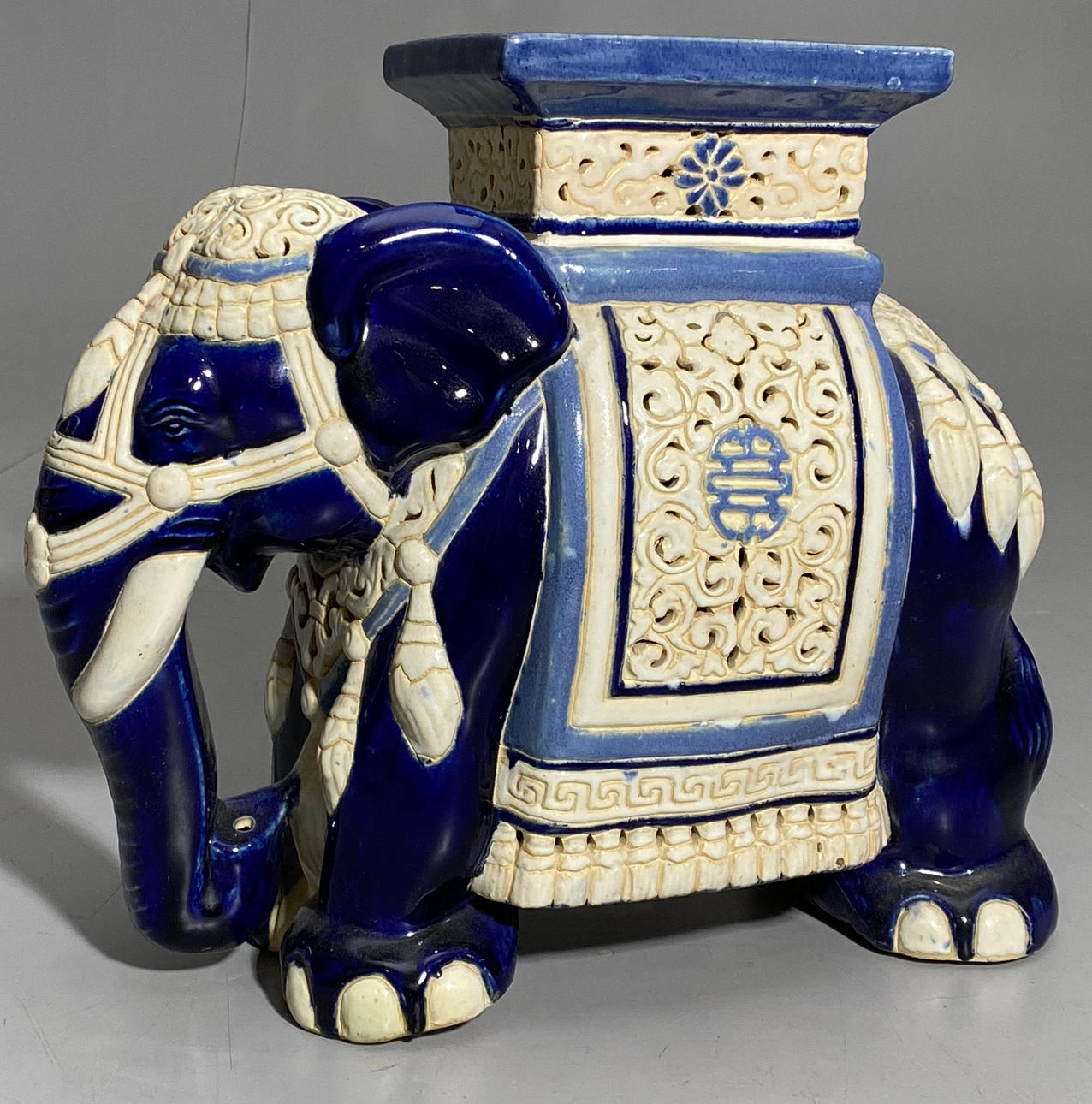 ELEFANTENFIGUR ALS ORIENTALISCHER HOCKER AUS GLASIERTER KERAMIK.