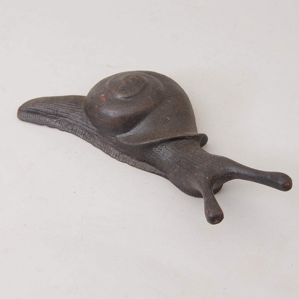 STÖVELKNEKT i form av snigel, gjutjärn, samtida.