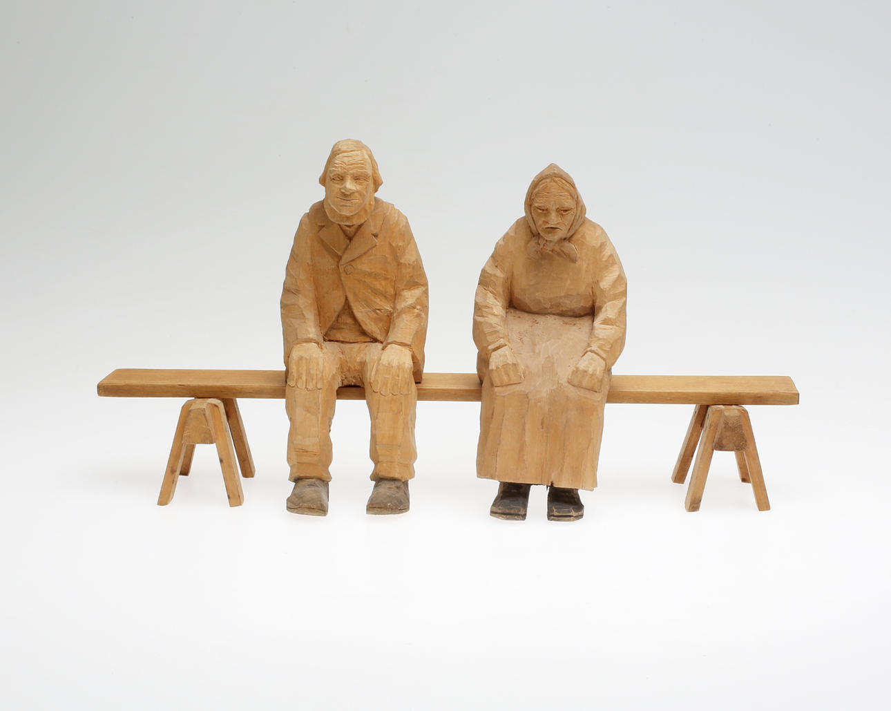 HELGE RUGLAND. Träskulpturer, man och kvinna på bänk, Rugstorparn, 1900-tal, signerade.