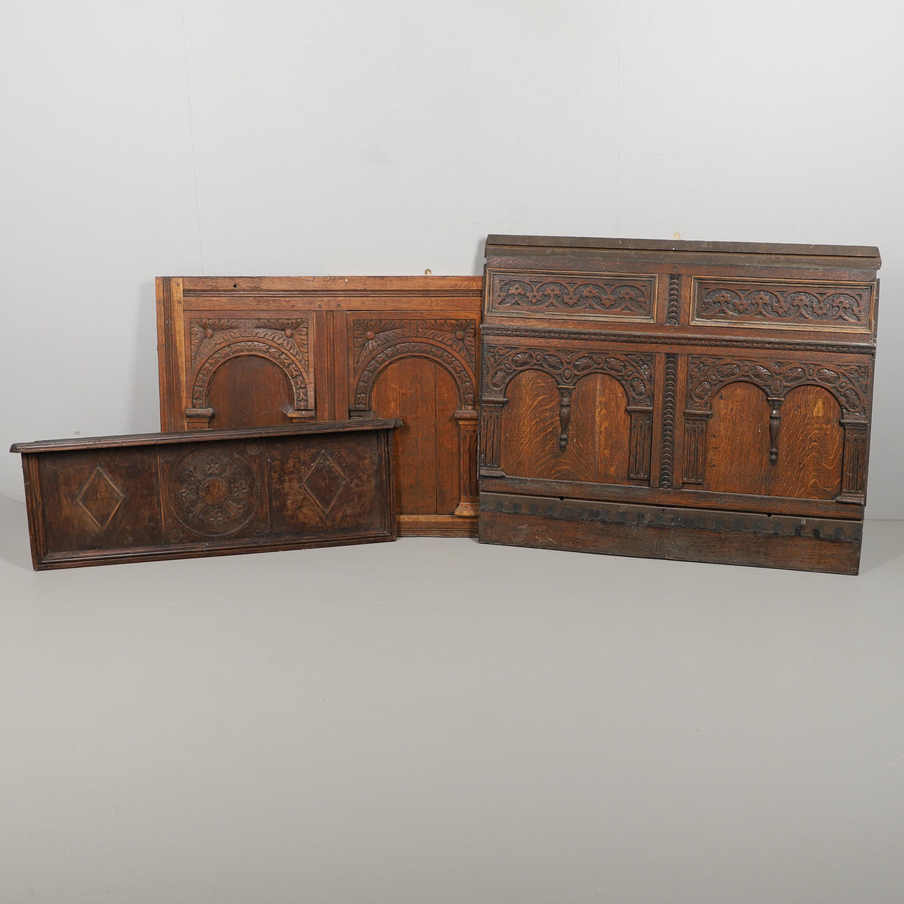 THREE CARVED OAK WALL PANELS.
