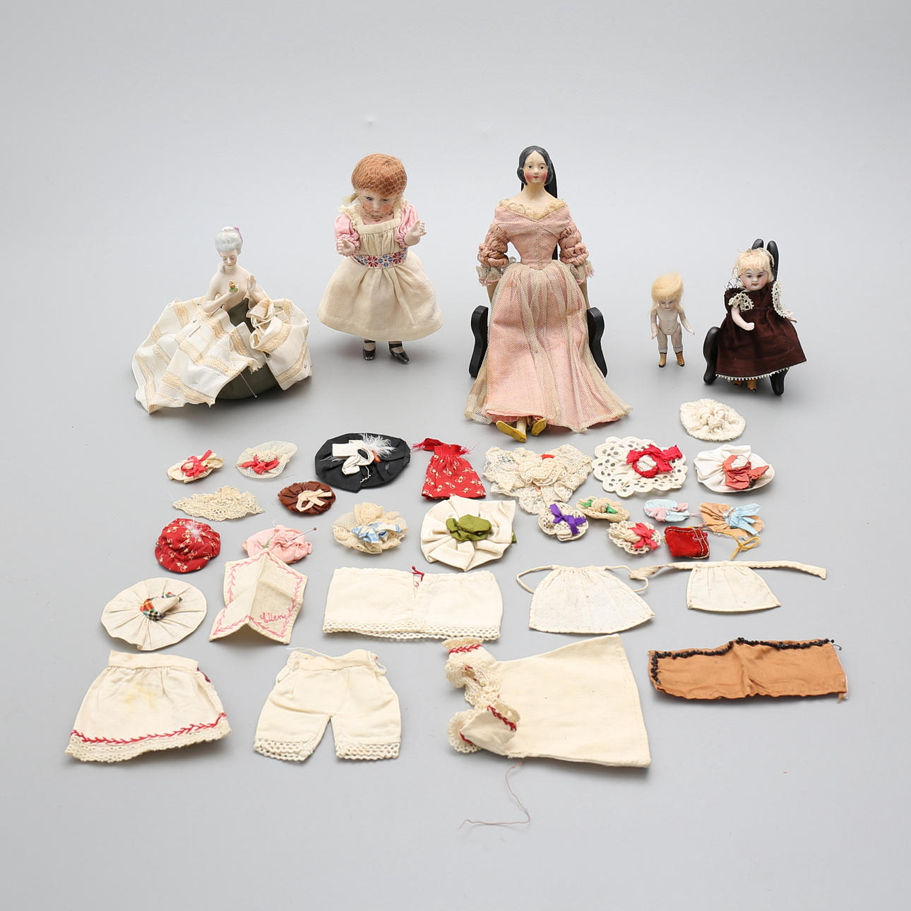 DOCKOR, 5 st, porslin och trä, samt dockkläder, 1800-tal.