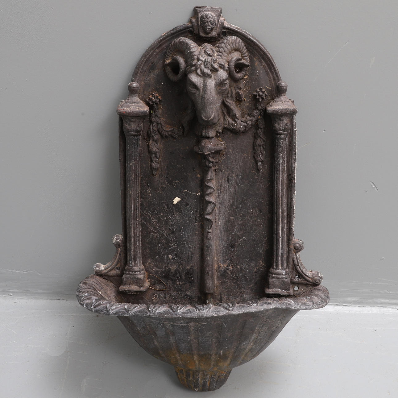 EIN BLEI WAND BRUNNEN, ÜBERSTEHEN MIT EINEM WIDDERKOPF.