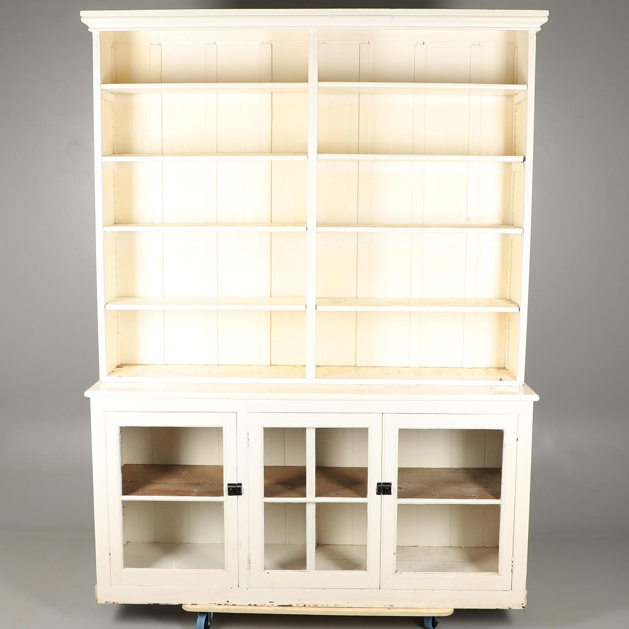 EN STOR MÅLAD ÖPPEN BOKHYLLA.