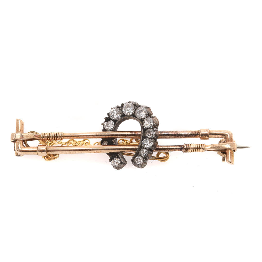 A LATE VICTORIAN BAR BROOCH IN THE FORM OF TWO RIDING CROPS CENTRED BY ...