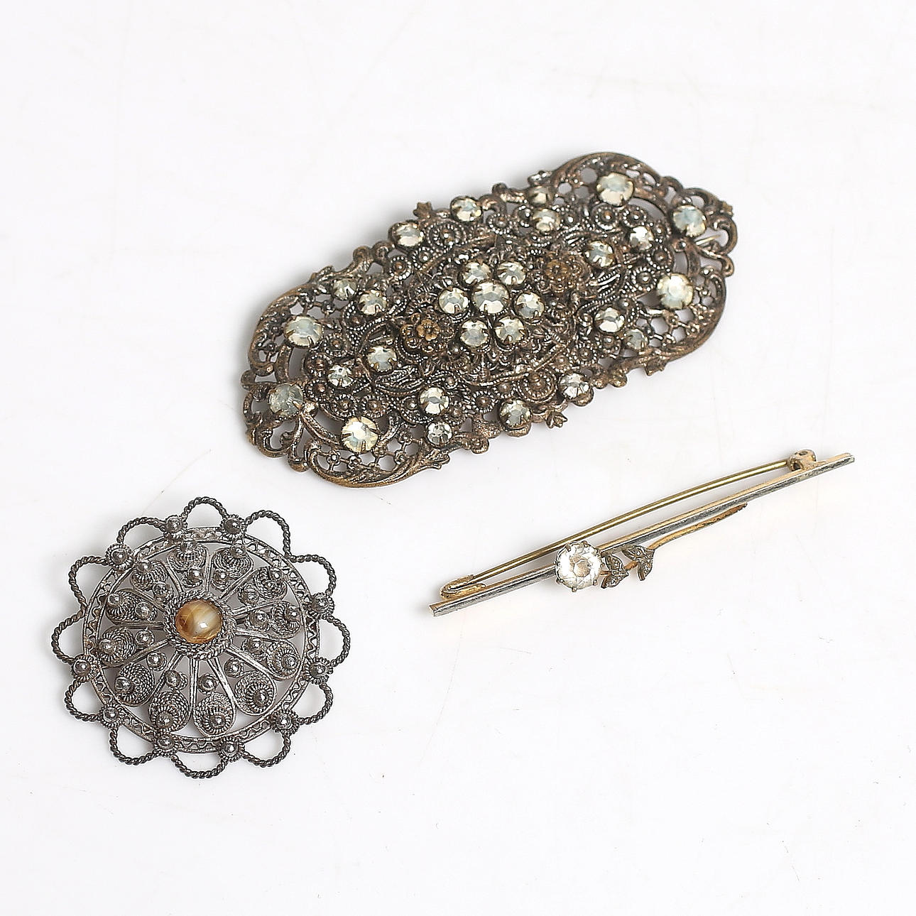BROSCHER samt KRAGNÅL, silver samt vitmetall med stenar. 1900-talets första hälft.