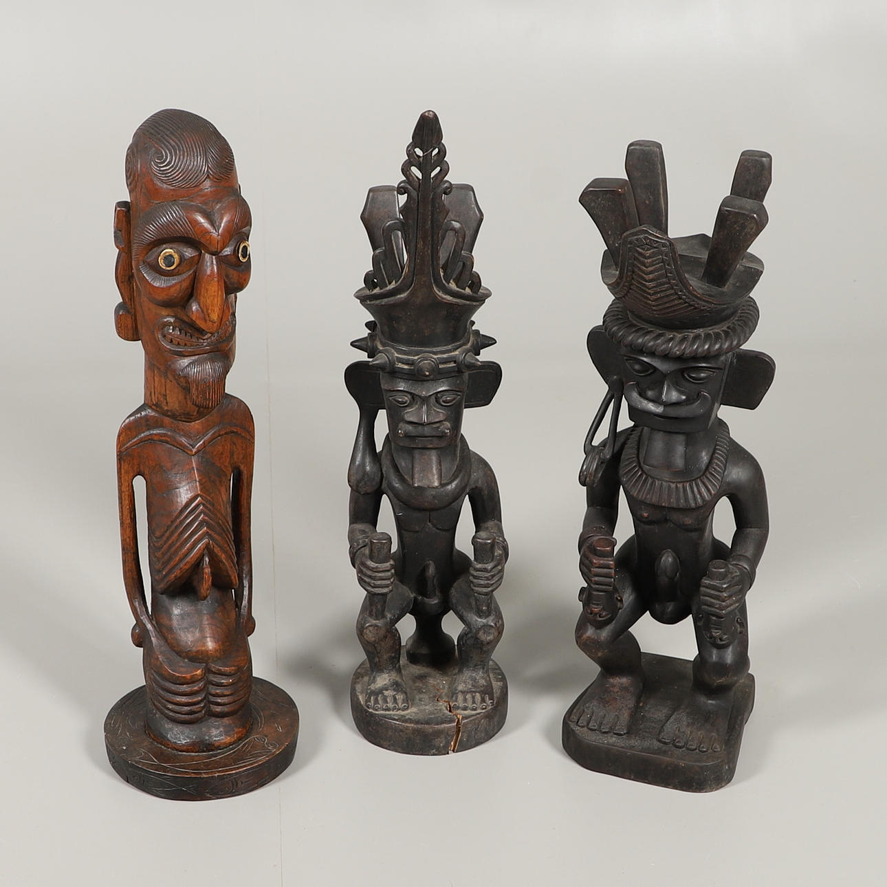 DREI GESCHNITZTE STAMMES-AHNENFIGUREN.