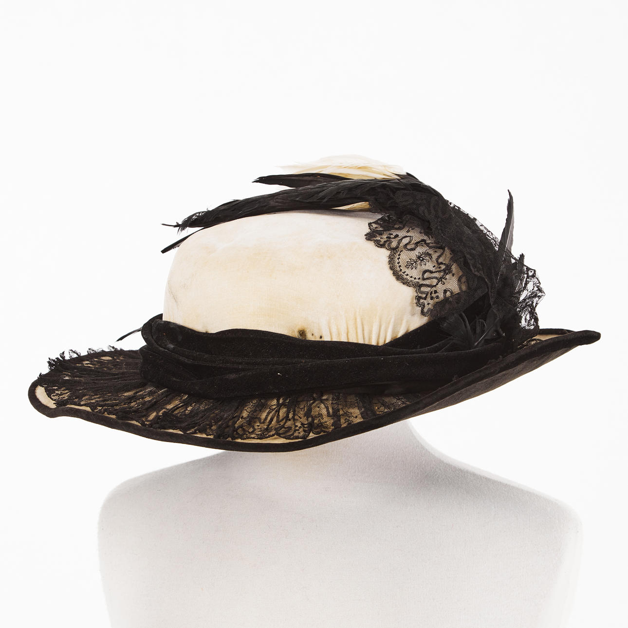 HAT, 1910s, made by hat seamstress Sofia Lindquist, Helsingborg, frame in stramalj, covered in light velvet, ribbon and edging in black velvet, brim covered with black tulle lace, brim with bird feathers, label inside, with original hat box.
