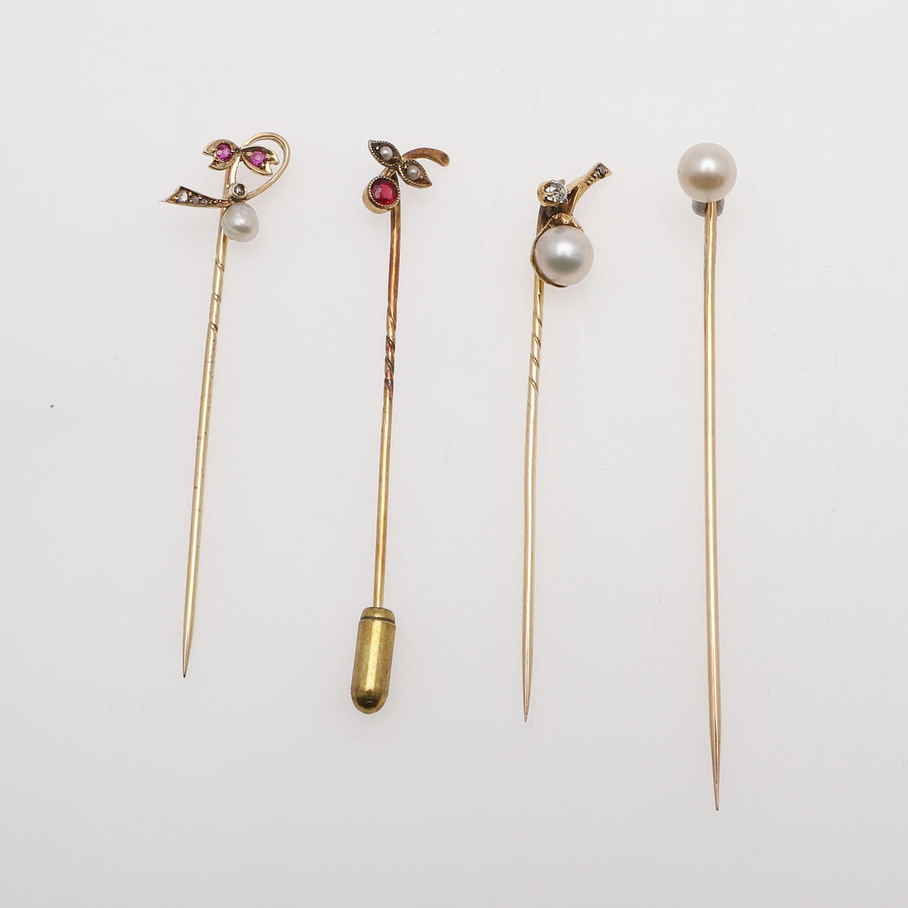 UN PIN DE RUBÍ, DIAMANTE Y PERLA.