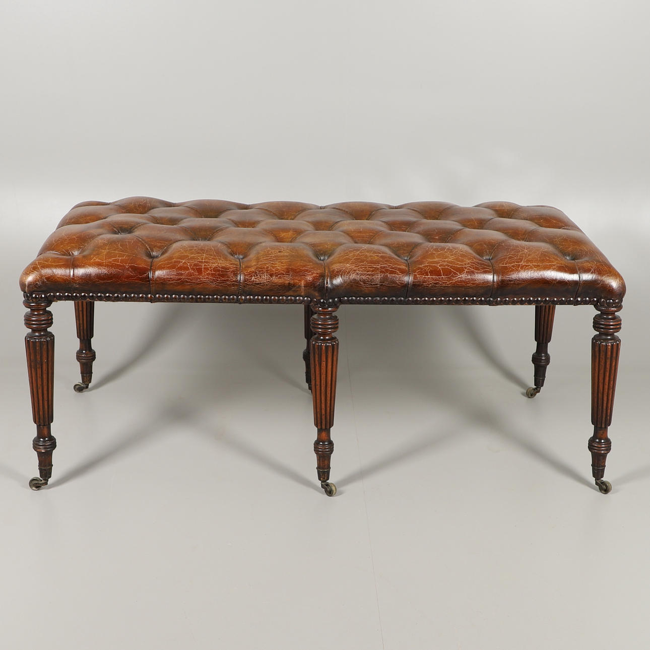 UN ASIENTO DE BIBLIOTECA DE CUERO CON BOTONES.