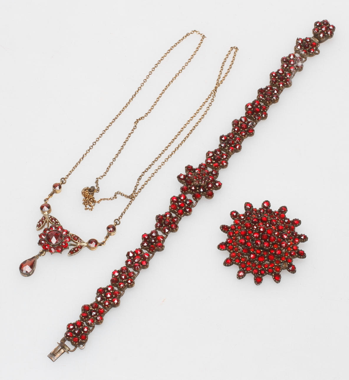 GARNITYR, 3 delar, gulmetall och granater, 1800/1900-tal.