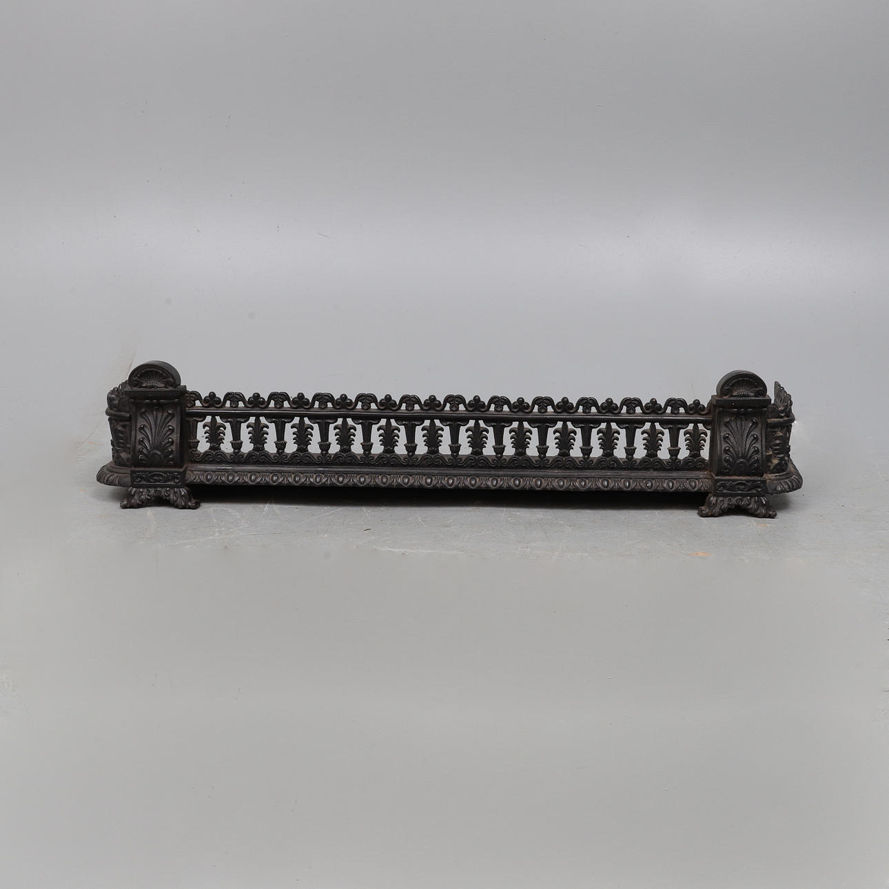 A LATE REGENCY BLACK PAINTED CAST IRON 'D' SHAPE FENDER.