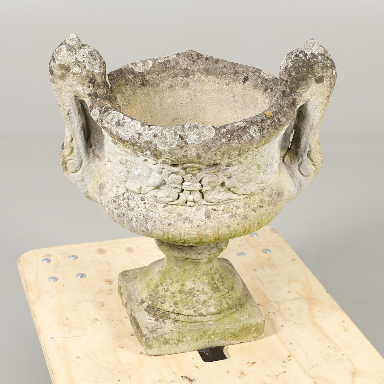 EN SAMMANSATT STEN TRÄDGÅRD URNA AV TROFÉ FORM.