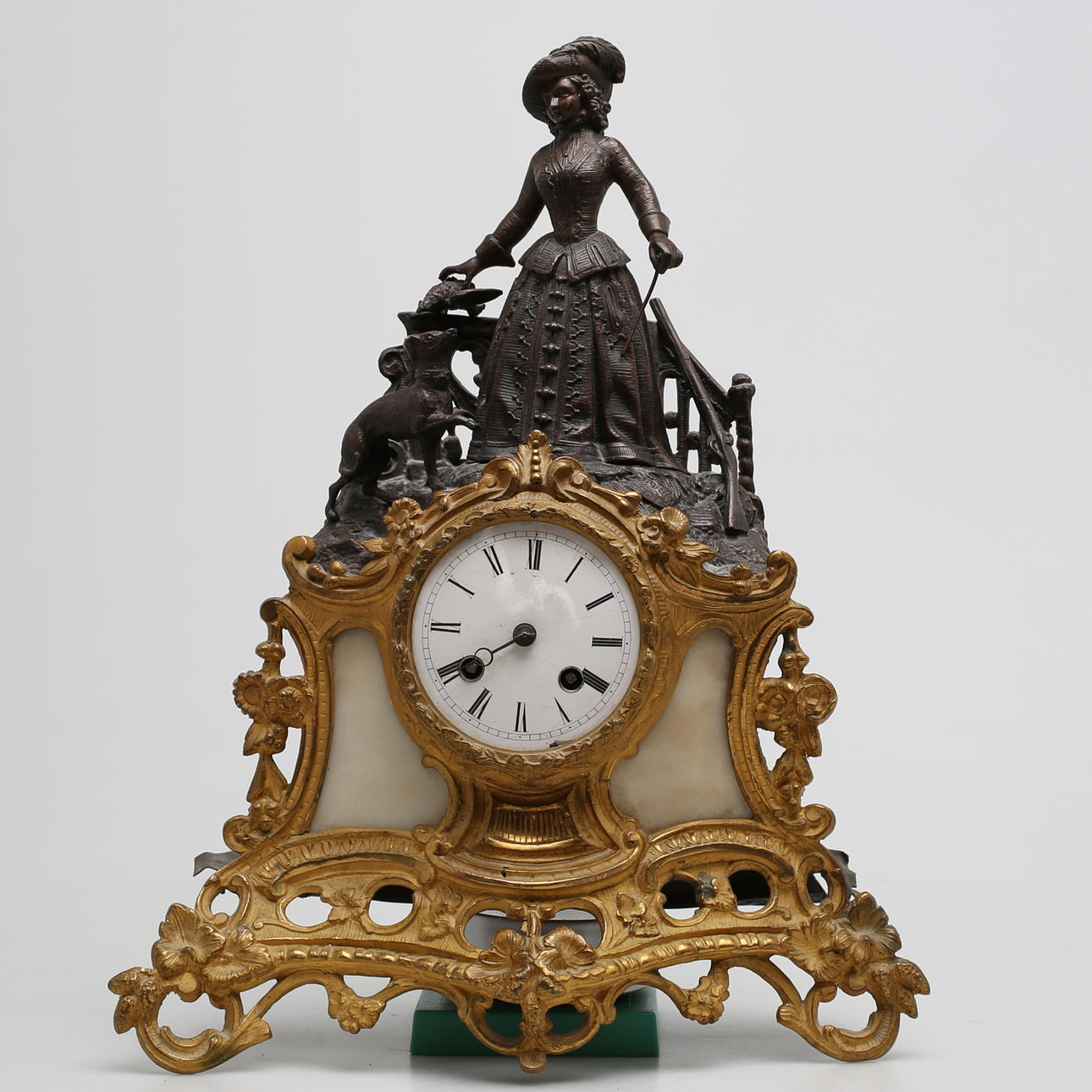 BORDSPENDYL i metall och alabaster, dekor av kvinna med hund, 1900-talets första hälft.