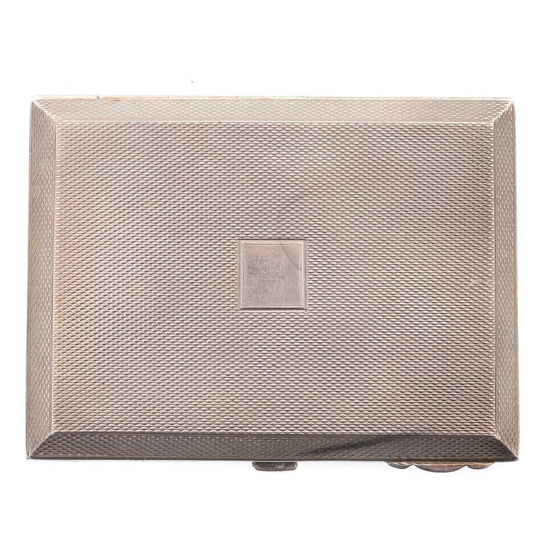 AN ART DECO RECTANGULAR ENGINE TURNED SILVER COMPACT.