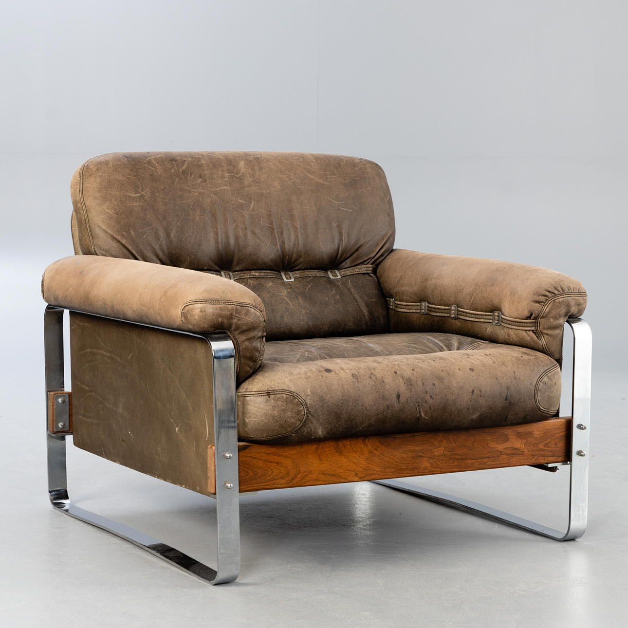 Sillón de cuero con patines cromados.