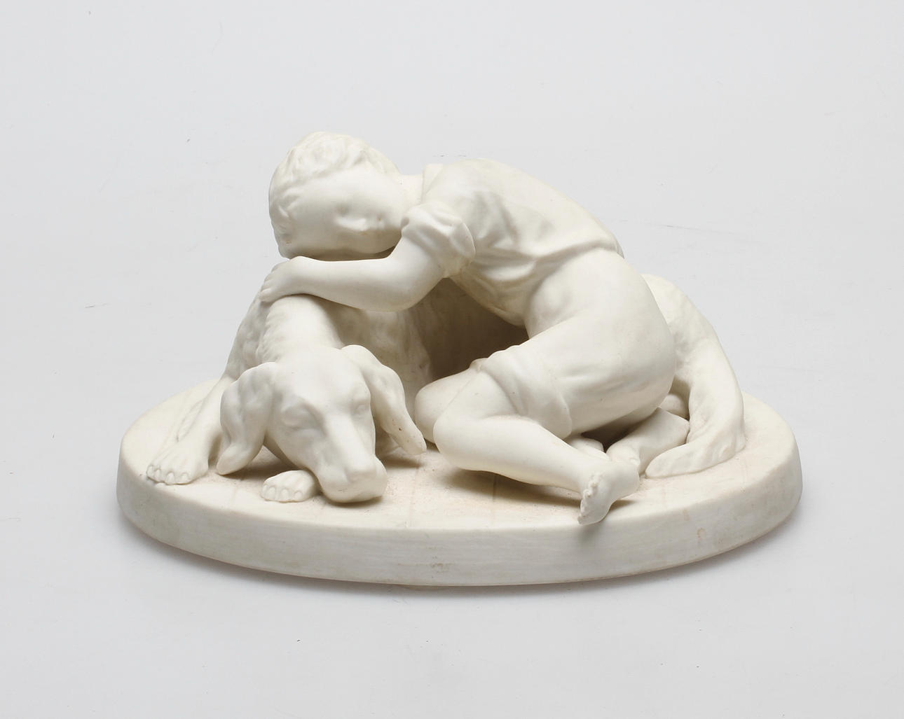 FIGURIN, parian, "Hund med pojke" efter A. Rudenschöld, Gustafsberg 1920, stämpelsignerad.