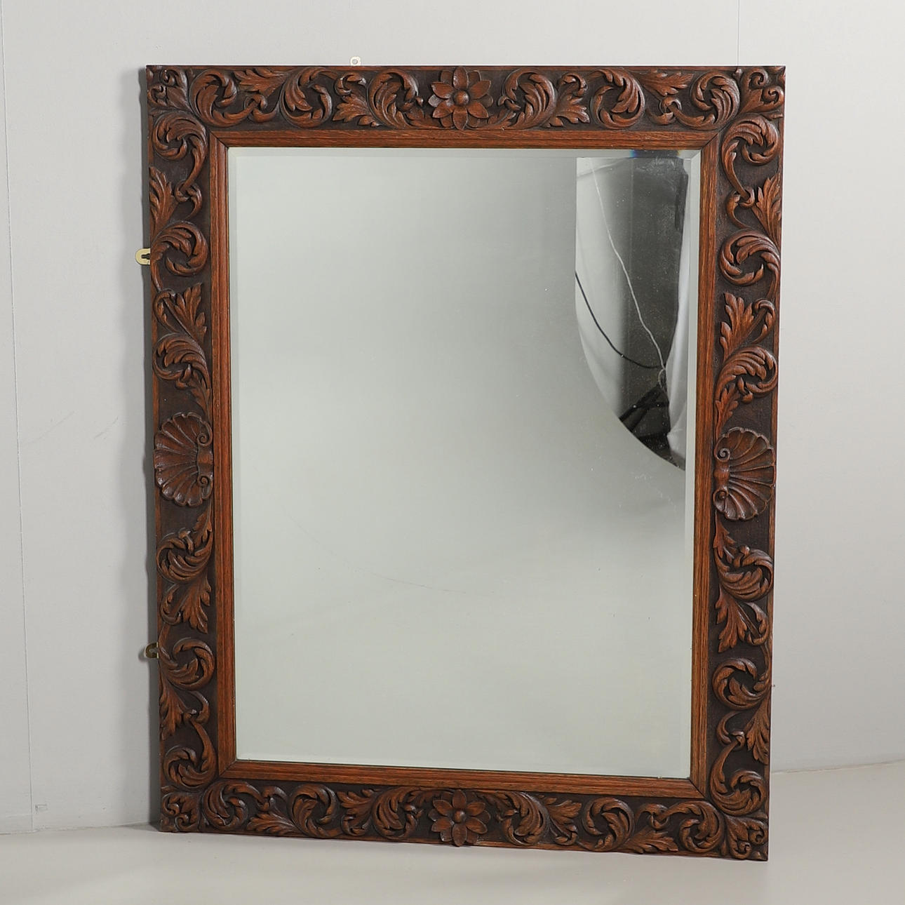 A LARGE OAK FRAMED MIRROR.