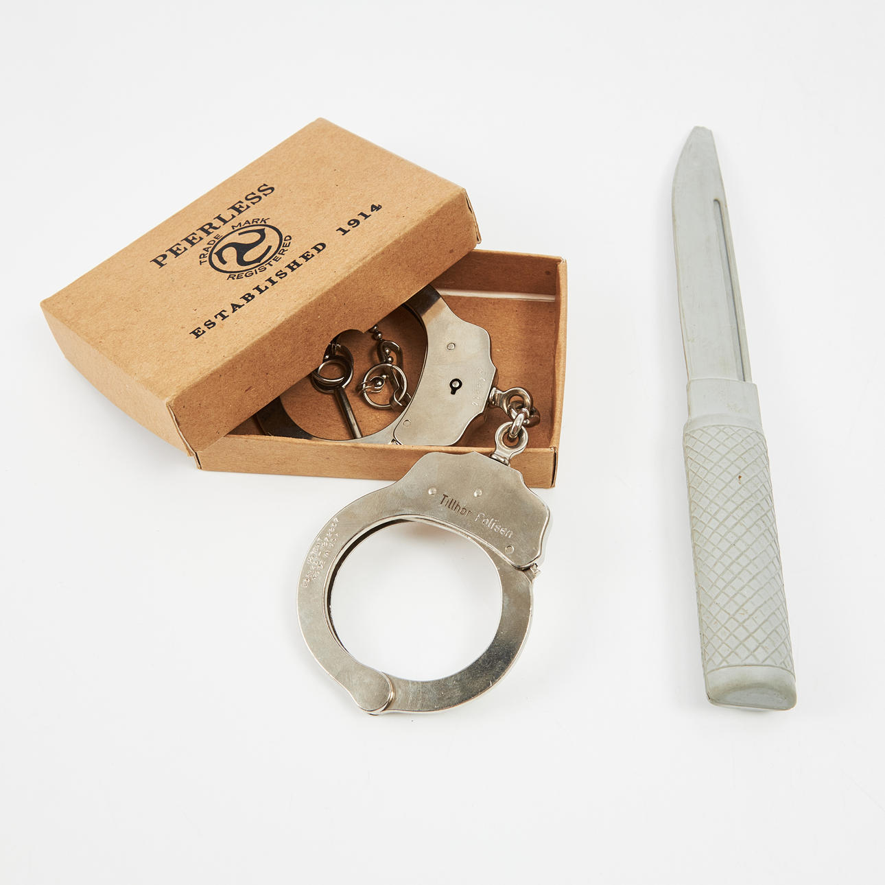 Handschellen sowie ein Gummi-Trainingsmesser der Polizei, Handschellen der Marke Peerless, mit Originalverpackung.