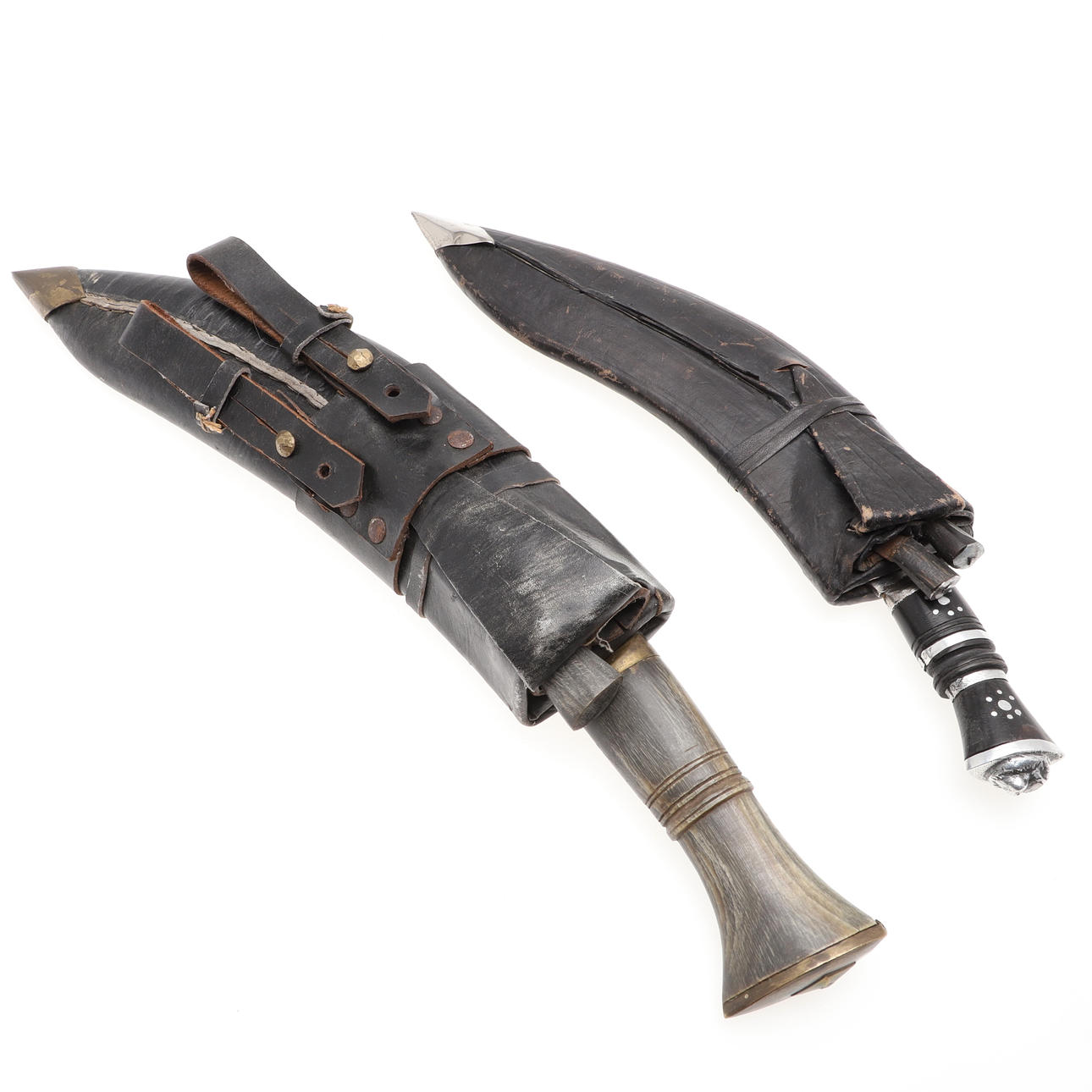 TWO KUKRI TYPE KNIVES IN LEATHER SCABBARDS.