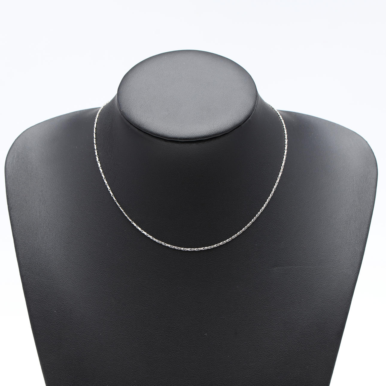 UNA CADENA DE CUELLO DE METAL BLANCO.