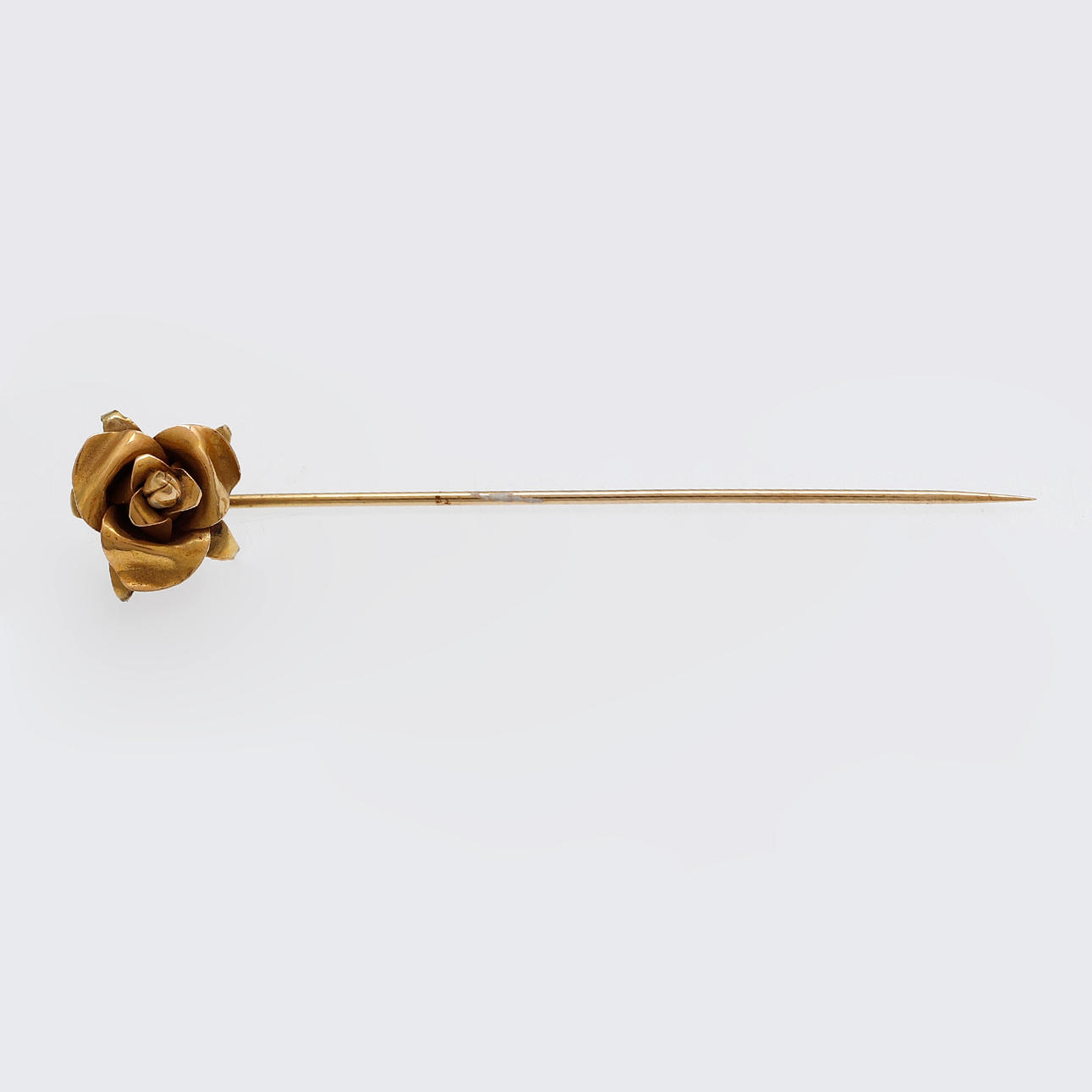 Rose-shaped gold tie pin.