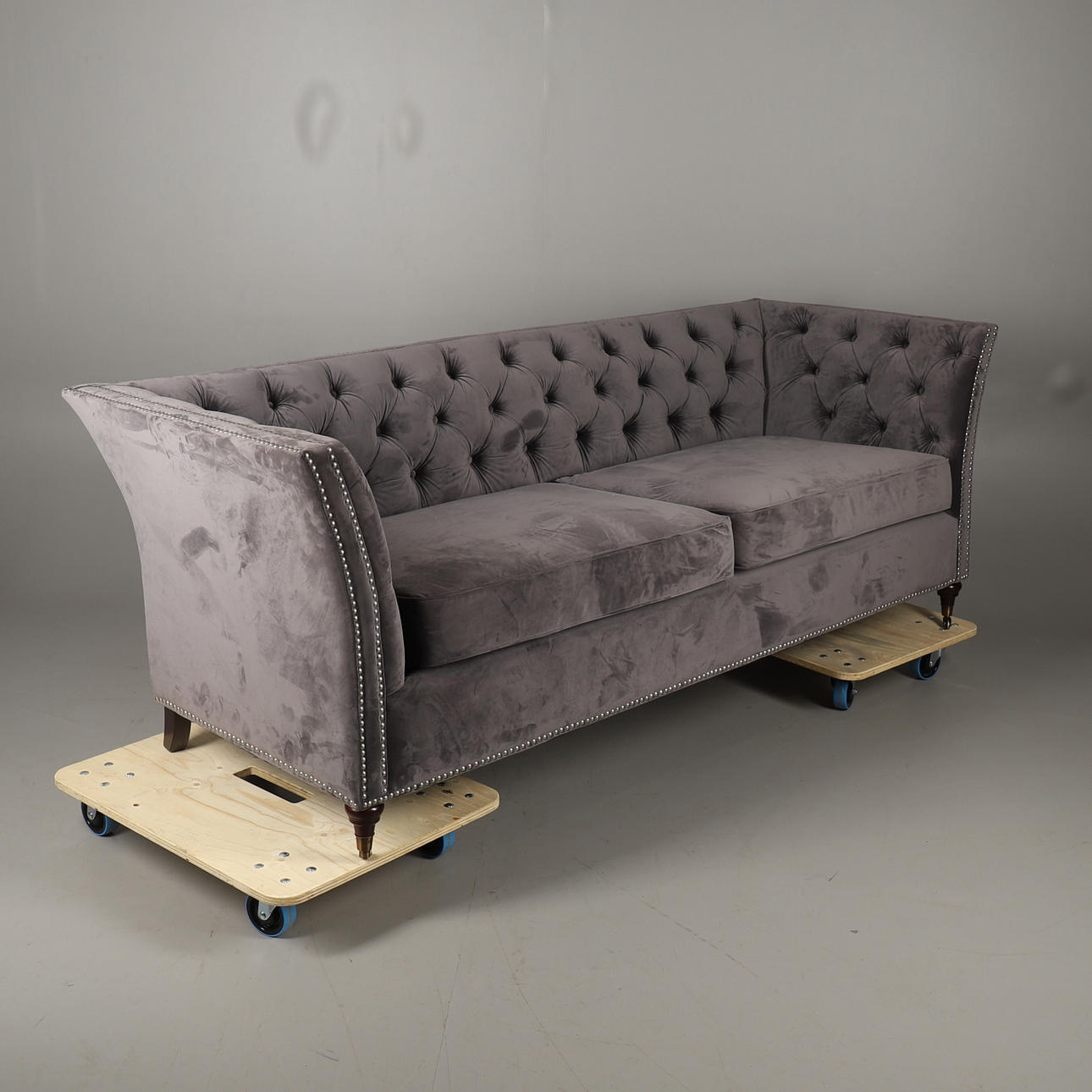 EN MODERN SAMMETSTOPPAD SOFFA MED KNAPPAR.