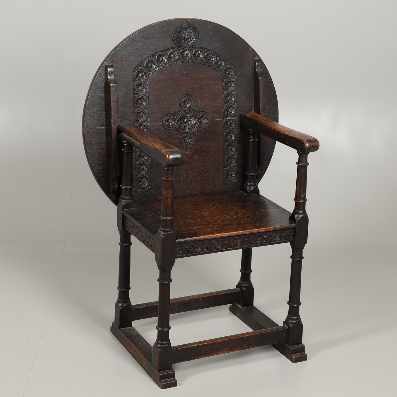 A CARVED OAK METAMORPHIC MONKS CHAIR.