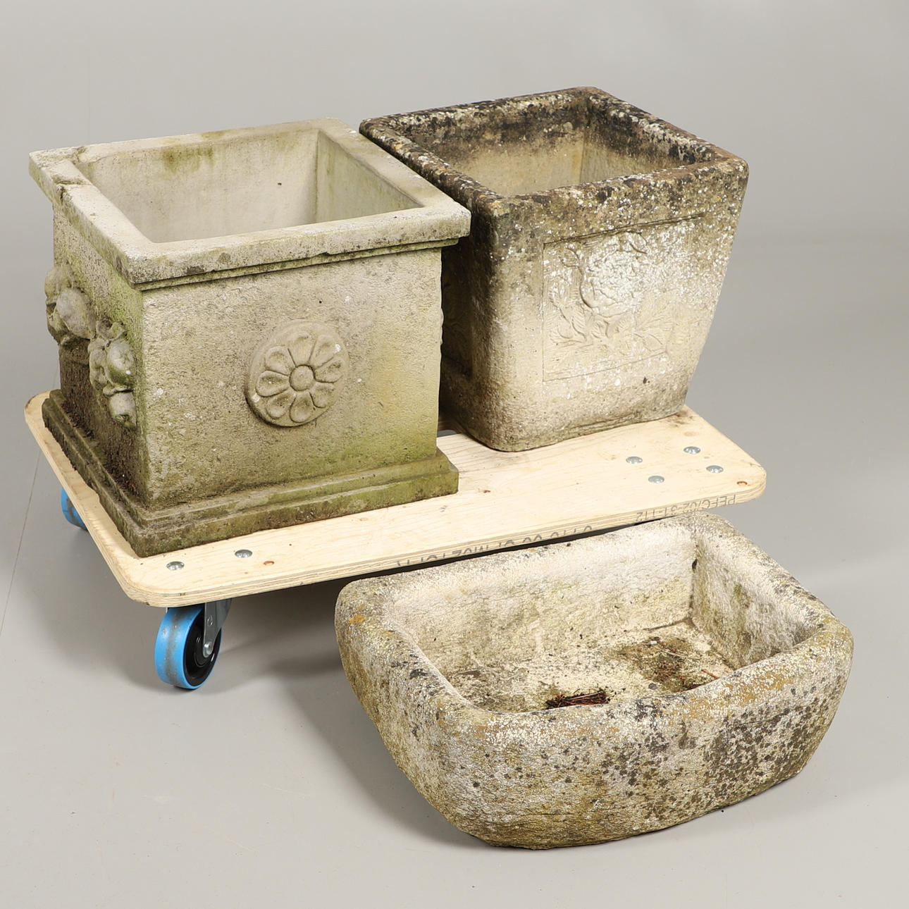 A SHALLOW CONCRETE TROUGH AND TWO SQUARE PLANTERS.