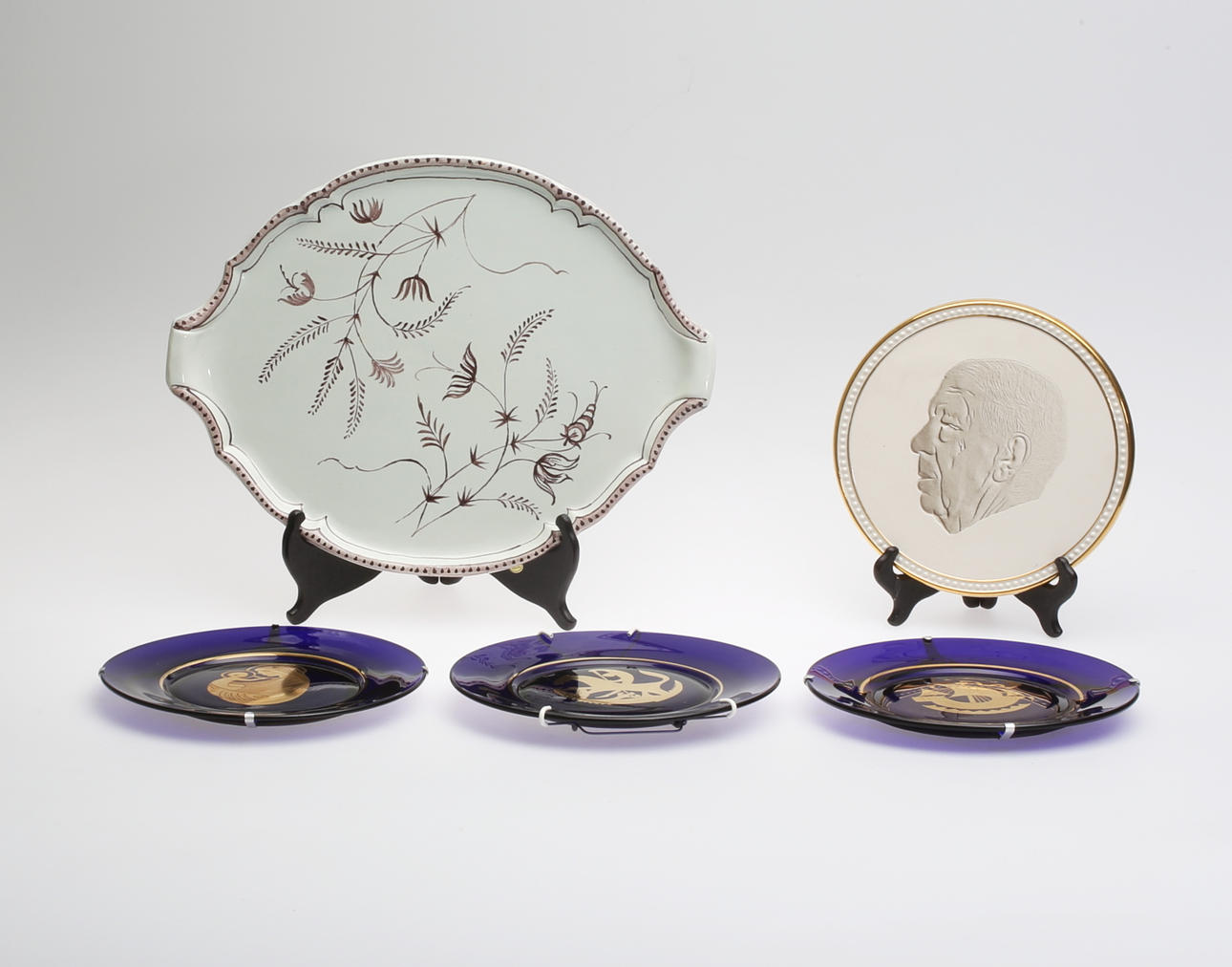 BRICKA, VÄGGPLAKETT samt TALLRIKAR, 5 delar, keramik och glas, 1900-tal.