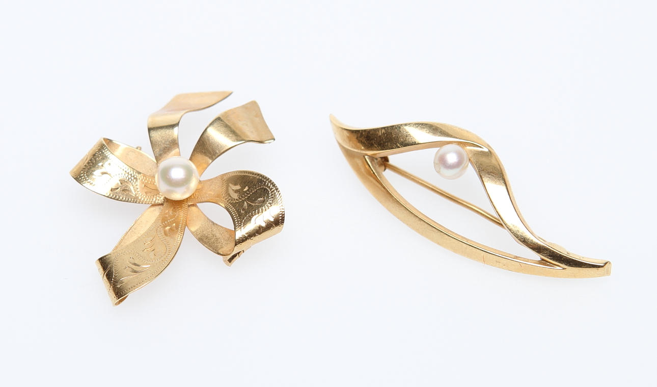BROSCHER. 2 st, 18k guld med pärla, ca 7,2 gram.