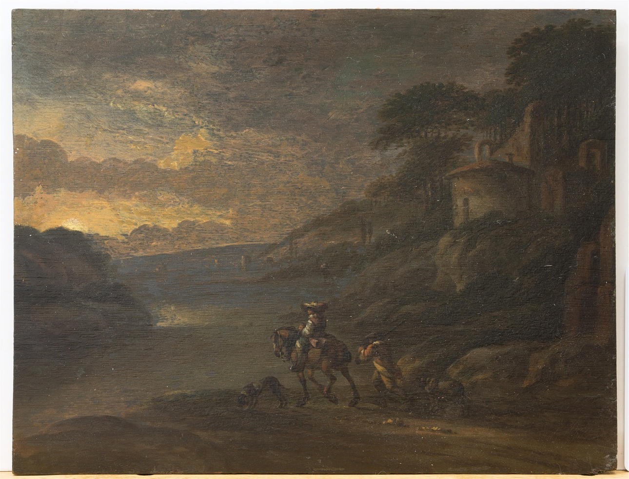 PHILIPS WOUWERMAN (1619-1668, HAARLEM). HANS ART. Solnedgång över ett sydligt flodlandskap med jägare som återvänder hem från jakt, olja på panel.