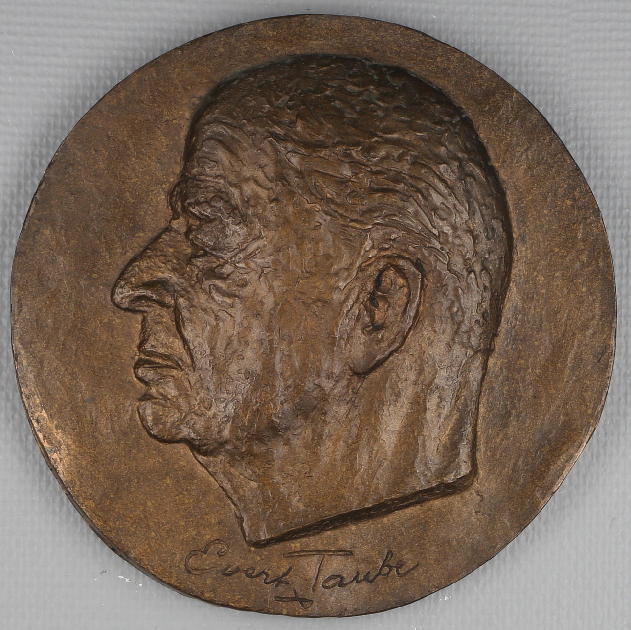 ASTRI BERGMAN-TAUBE. Bronsplakett, föreställande Evert Taube, signerad Astri Bergman-Taube.