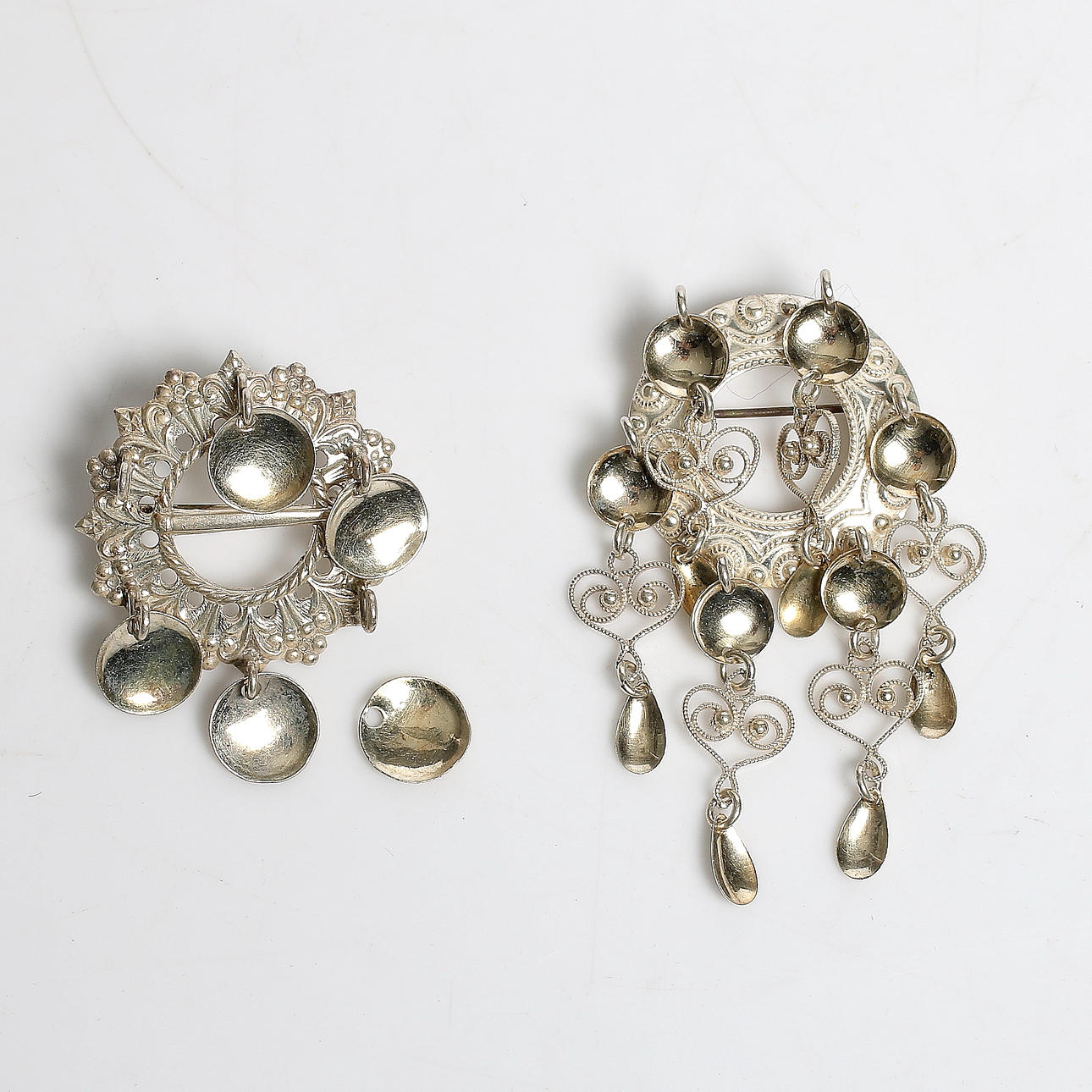 BROSCHER till folkdräkt, silver. 1900-tal.