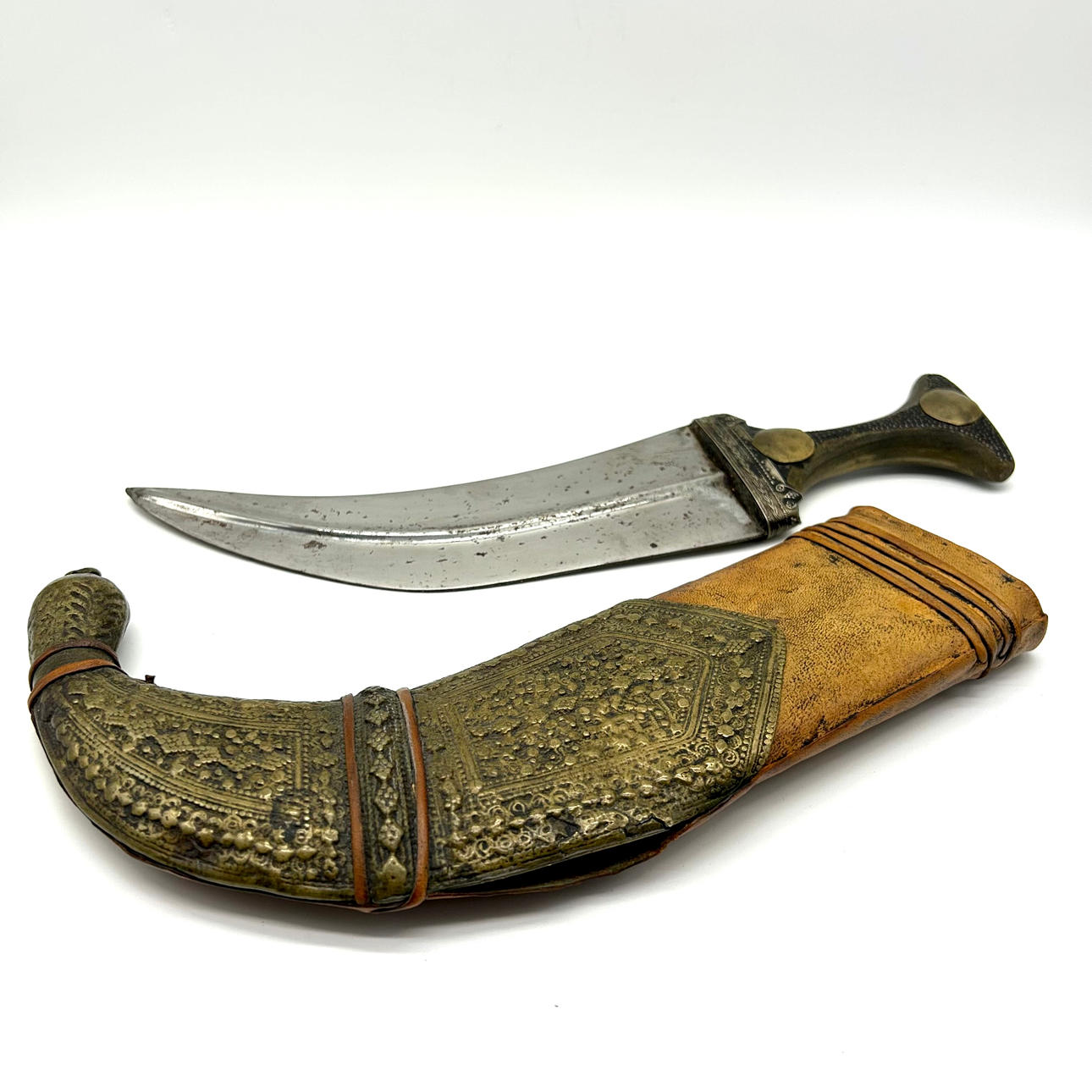 ELEGANT BLADE - CURVED DAGGER WITH LEATHER SHEATH AND INVOLVED BRASS DECORATION.