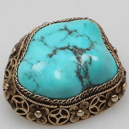 BROSCH i förgyllt silver besatt med turkoslik sten.