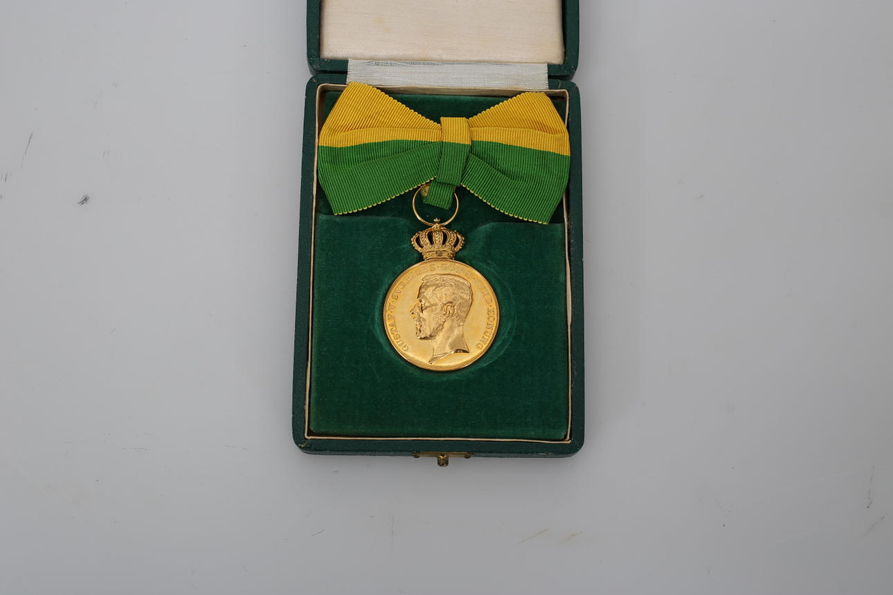 MEDALJ, 18 och 23 K guld, "För lång och trogen tjänst", 23,6 gram med rosett.