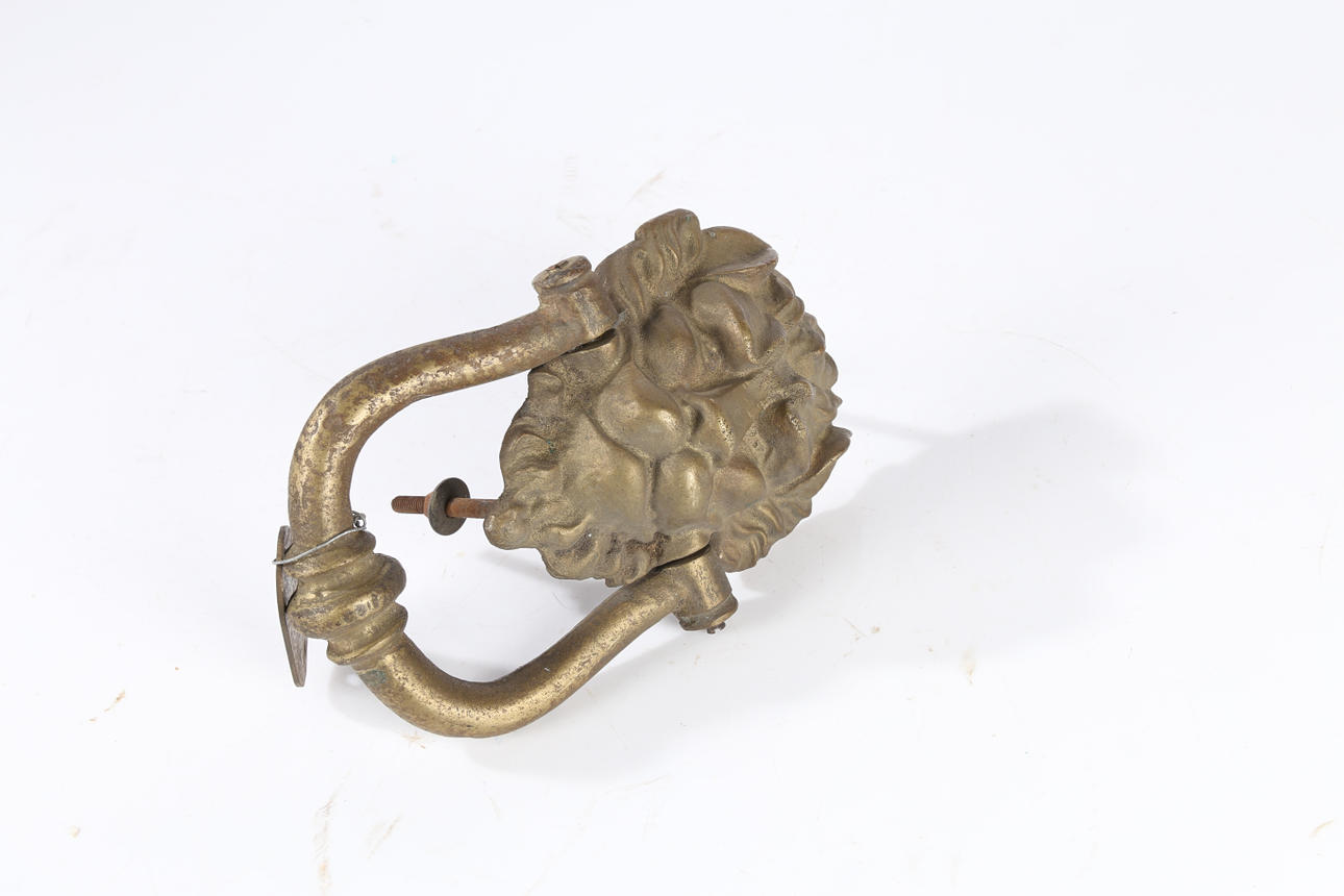 EN DÖRRKNACKARE FÖR LEJONMASK I MÄSSING.