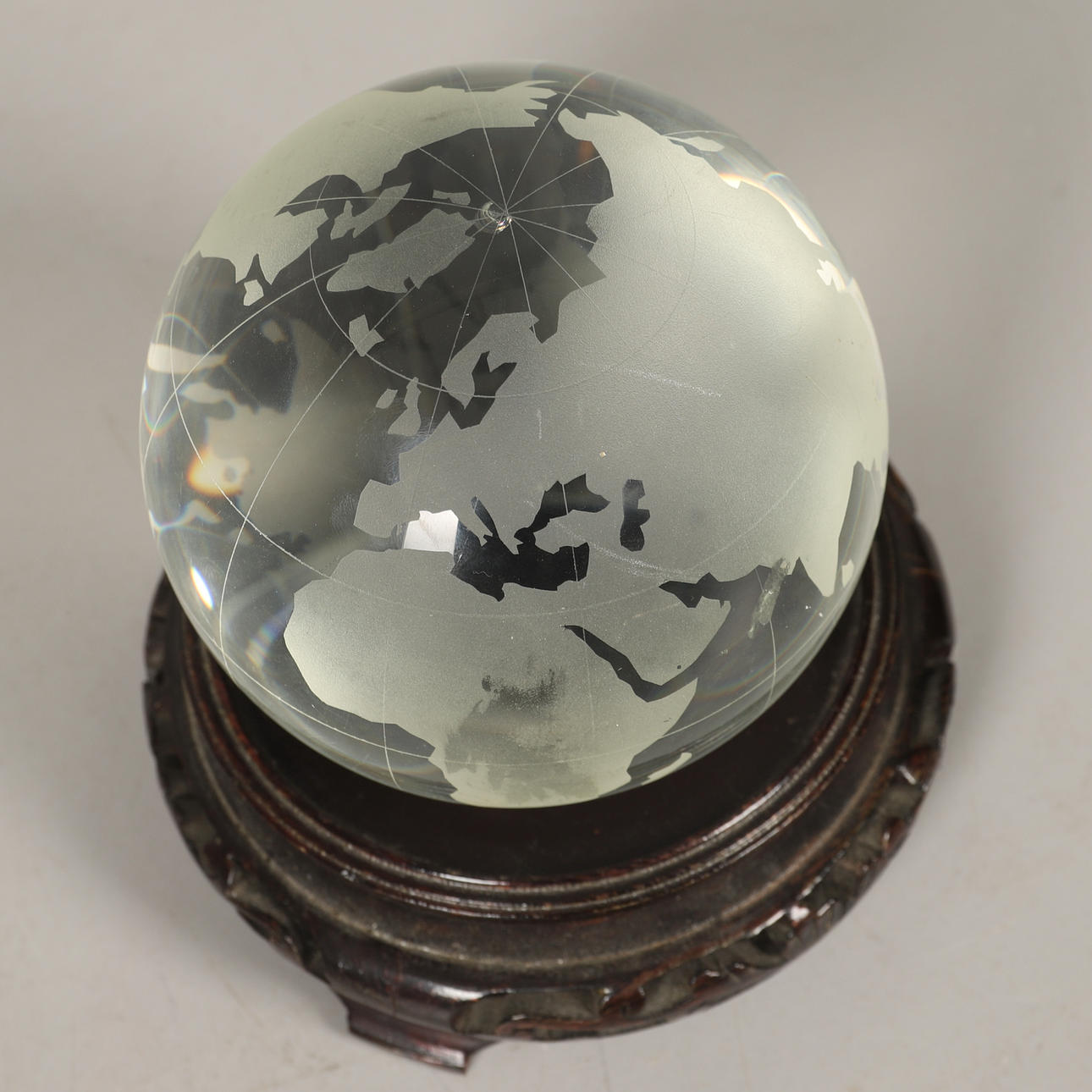 AN ETCHED GLASS GLOBE ON ASSOCIATED STAND.
