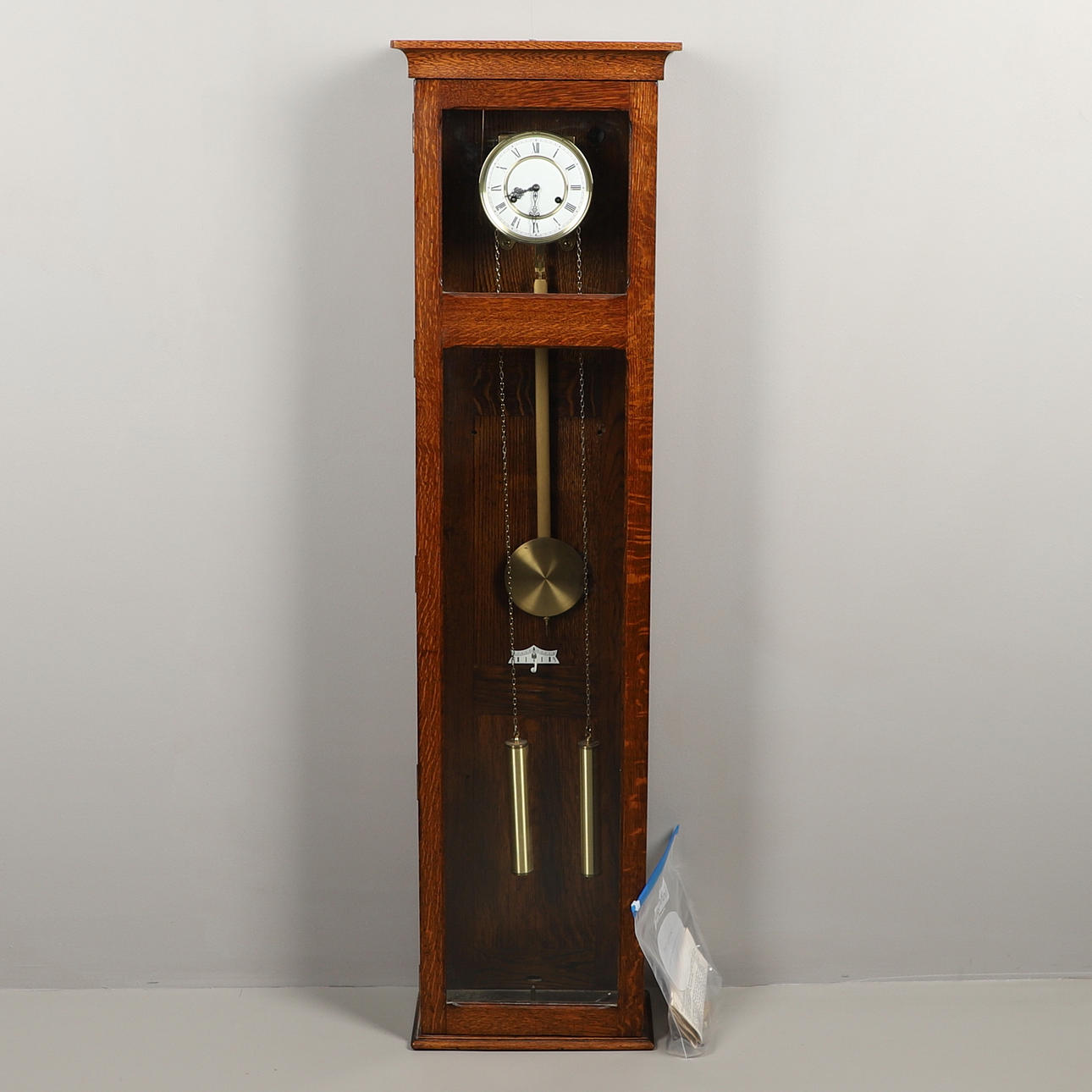 EINE LANGE WANDUHR MIT EICHENGEHÄUSE.