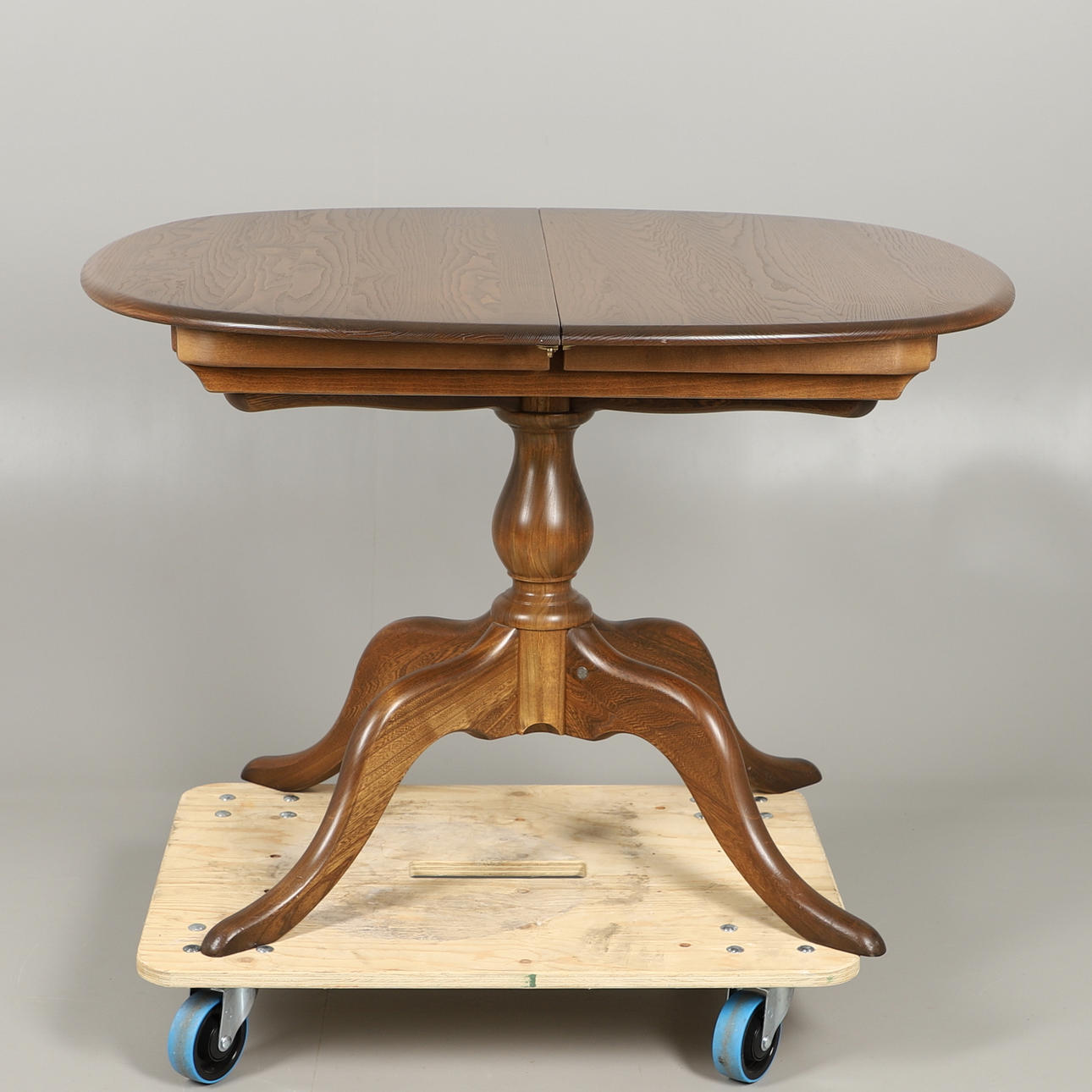 AN ERCOL GOLDEN DAWN CHESTER EXTENDING DINING TABLE.