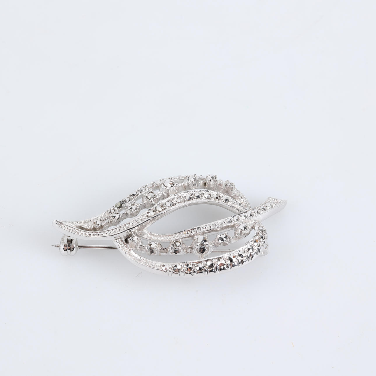 BROSCH i silver med vita stenar.