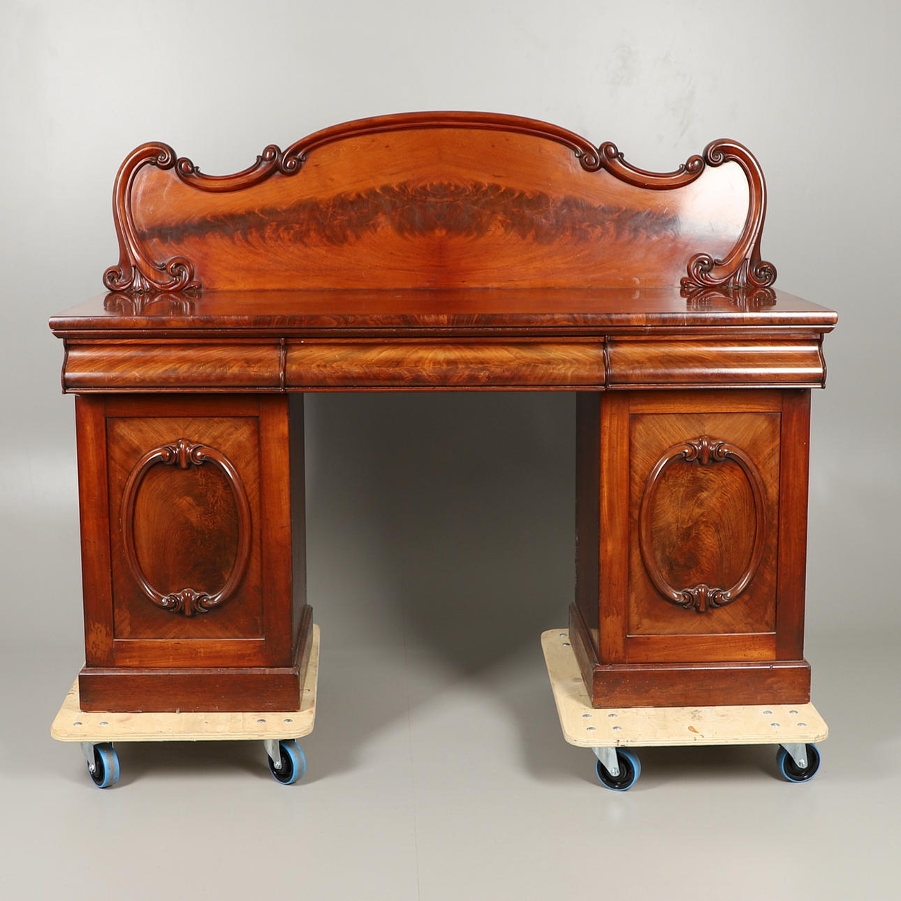 A VICTORIAN FLAME MAHOGANY PEDESTAL SIDEBOARD.