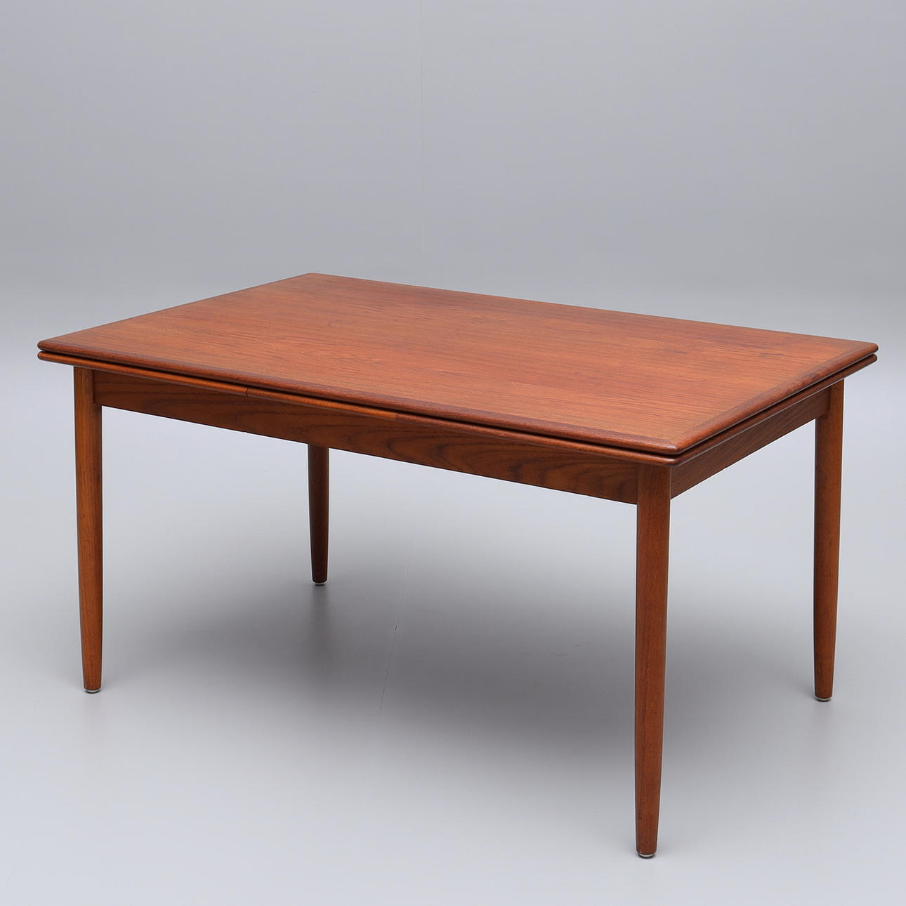 Una mesa de comedor de teca de los años 60 con platos extraíbles.