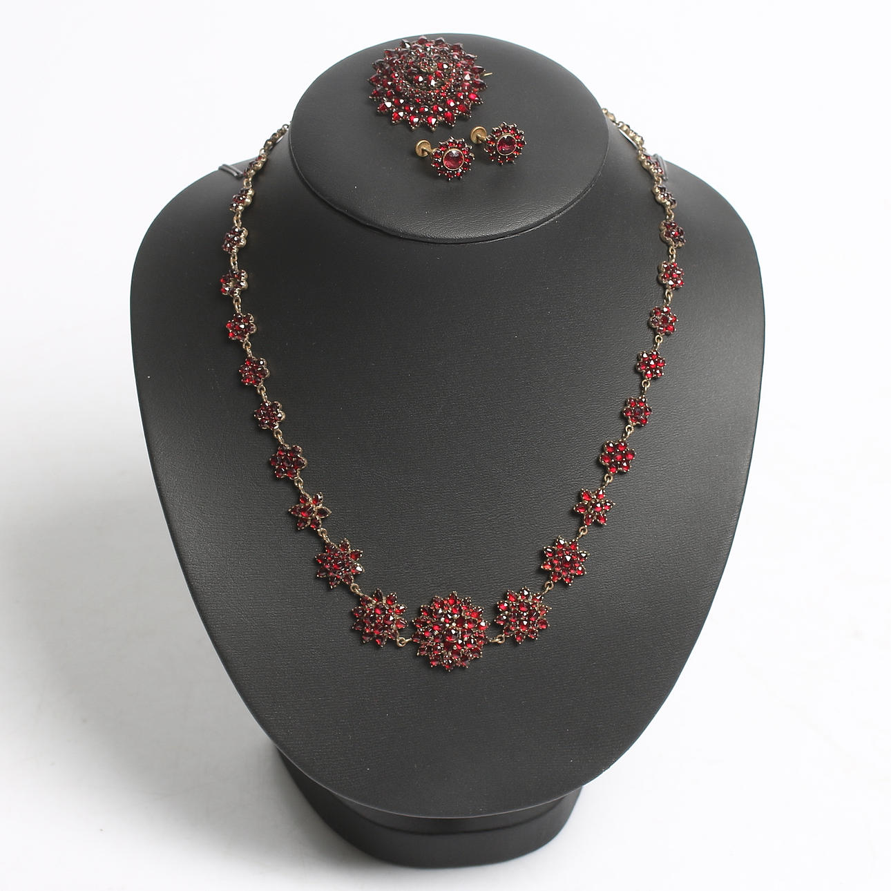 COLLIER, ÖRHÄNGEN samt BROSCH, mässing och granater. Sekelskiftet 1800/1900.